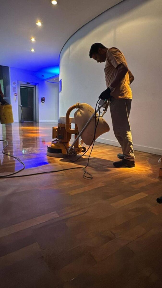 colaborador da Cortez Restaura utilizando maquinário para restaurar o piso de madeira na IFF