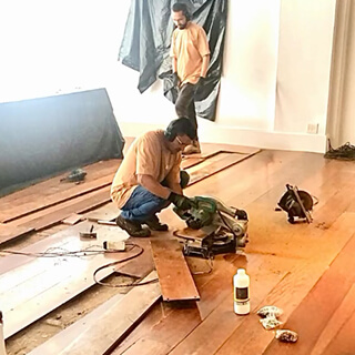 colaboradores da Cortez Restaura usando maquinário no piso de madeira da Rádio Antena 1
